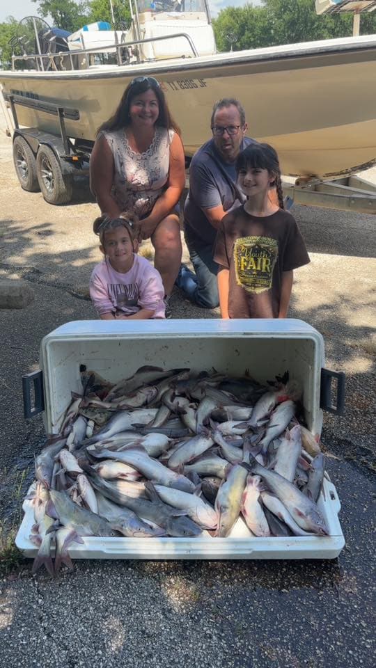 Family with a cooler full of catfish